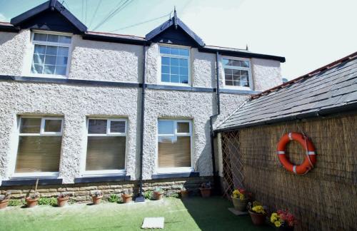 a house with a red lifesaver on the side of it at The Coach House Apartment in Lytham St Annes