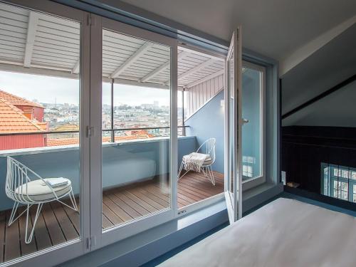 a balcony with sliding glass doors and a chair at Apartamentos The Arc Carrís in Porto