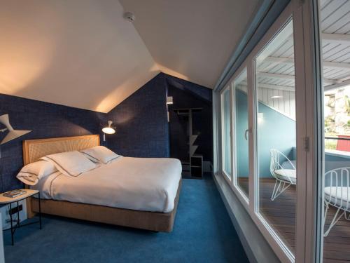 a bedroom with a bed and a balcony at Apartamentos The Arc Carrís in Porto