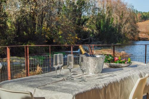 a table with wine glasses and a bowl of flowers at Azenha do Trigo in Rendufe
