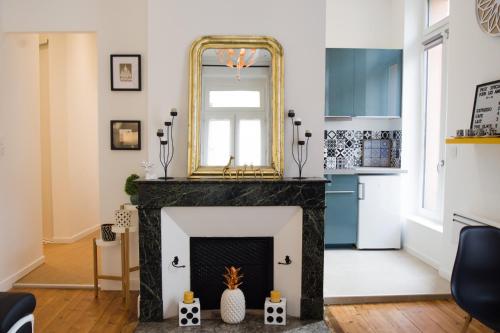 een woonkamer met een open haard en een spiegel bij Le Saint-Aubin by Cocoonr in Toulouse