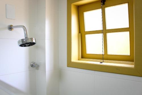 uma casa de banho com uma janela e um chuveiro em Pousada Primaz de Minas em Mariana