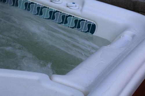 a bathtub filled with water with a paddle in it at Maison Jules in Sainte-Ode