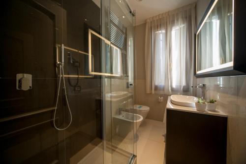 a bathroom with a shower and a toilet and a sink at Hotel Grande Italia in Chioggia