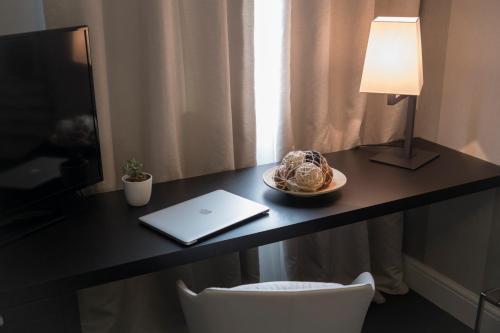 a desk with a laptop and a plate of food on it at Hotel Grande Italia in Chioggia