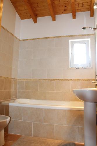 a bathroom with a bath tub and a sink at Casa Guna in Aljezur