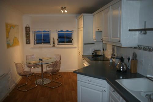 uma cozinha com uma mesa e uma pequena mesa com cadeiras em No 10 Royal Apartments em North Berwick