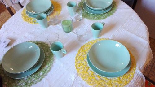 a table with plates and glasses on a white table cloth at DiVino in Villa Viani