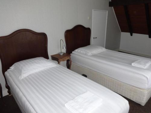 
a hotel room with two beds and two nightstands at Bed and Breakfast Corvel in Tilburg
