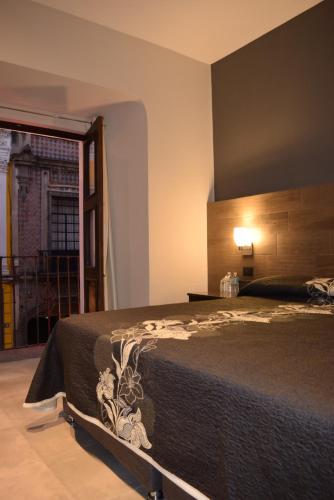 a bedroom with a bed and a view of a building at Hotel Sofia in Puebla