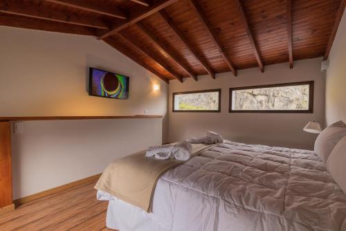 1 dormitorio con 1 cama grande y 2 ventanas en Andino Aparts - El Chaltén en El Chaltén