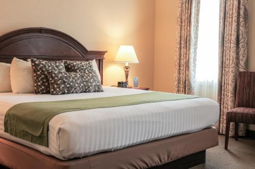 a bedroom with a large bed and a chair at The Conwell Inn in Philadelphia
