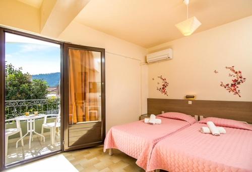 a bedroom with two beds and a balcony at Takis Hotel Apartments in Ialysos