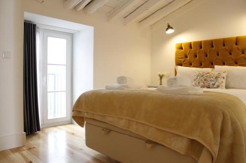 a bedroom with a large bed and a window at Augusta Street - 4 Esq in Lisbon