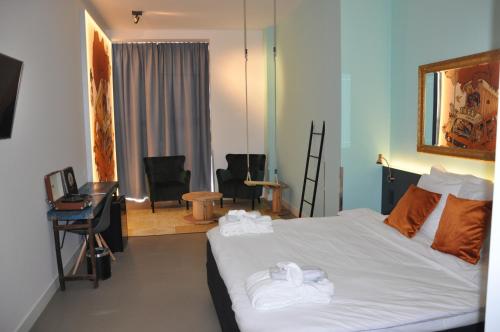 a bedroom with a bed with towels on it at Hotel Rauw aan de Kade in IJmuiden