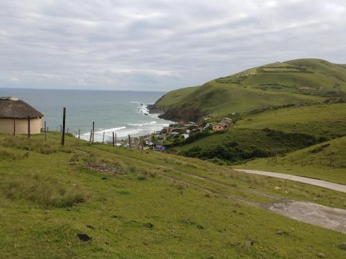 a view of the ocean from a grassy hill at Hillside View Guesthouse in Coffee Bay