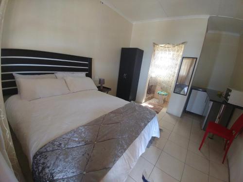 a bedroom with a bed and a desk and a window at Hillside View Guesthouse in Coffee Bay