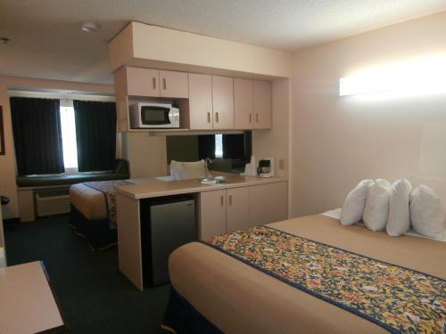 a hotel room with two beds and a kitchen at America's Best Value Inn & Suites-McDonough in McDonough
