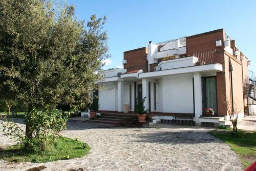 un gran edificio de ladrillo con un árbol delante de él en Axia Terme B&B, 4 min dal Centro Storico - PARK privato en Viterbo