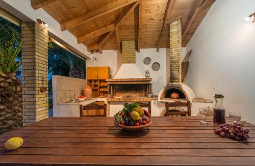 un plato de fruta en una mesa de madera en la cocina en Helen & Theo, en Laganas