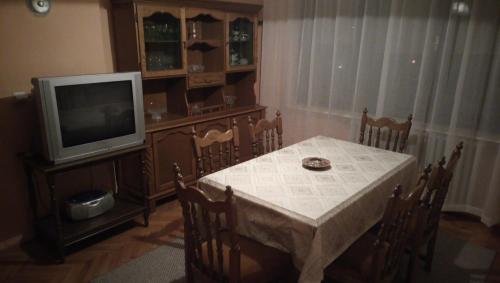 a dining room with a table and a television at Stan na dan Banja Luka in Banja Luka