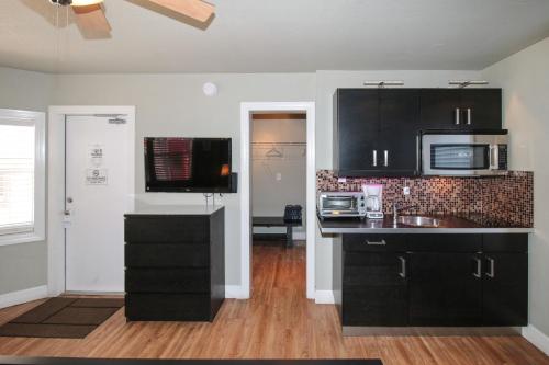 a kitchen with black cabinets and a microwave at Sun Beach Inn in Hollywood