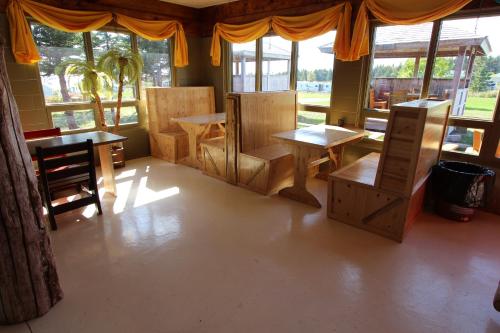 a room with wooden tables and chairs and windows at Chalets Nature Océan in Perce