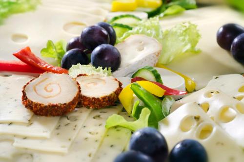 a plate of food with cheese grapes and vegetables at Hotel am Hofgarten in Düsseldorf