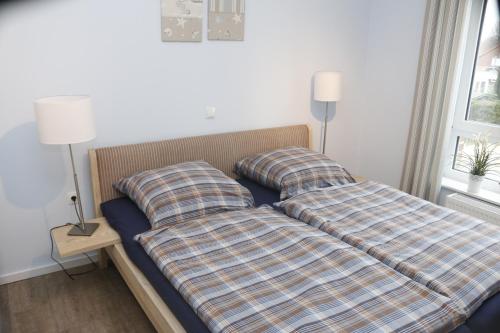 łóżko z 2 poduszkami w pokoju w obiekcie Strandgut w mieście Horumersiel