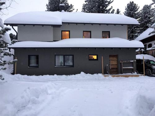 una casa cubierta de nieve con mucha nieve en Grünseeappartement en Turracher Hohe