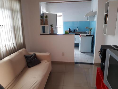sala de estar con sofá y cocina en Flight Crew Hostel, en Belo Horizonte