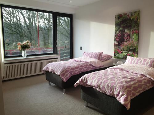 Un dormitorio con dos camas y una ventana. en Villa am Hülser Berg nähe Düsseldorf, en Krefeld