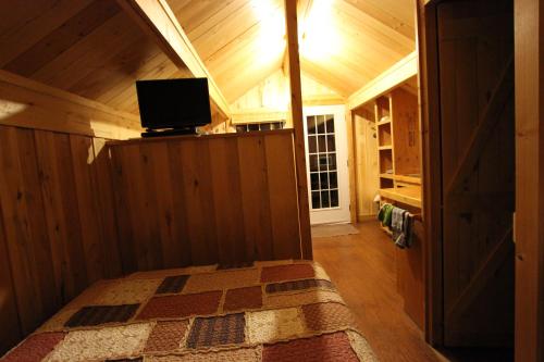 a bedroom with a bed with a tv on top at Chalets Nature Océan in Perce