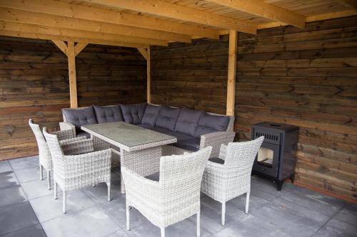 a patio with a table and chairs and a fireplace at de rode beer (zeer rolstoelgeschikt) in Heerde