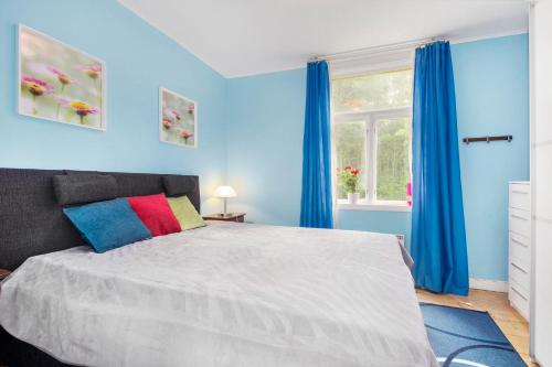 um quarto com uma cama grande com paredes azuis e uma janela em Ferienhaus am Mycklaflon em Eksjö