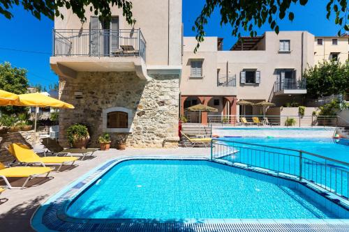 a swimming pool in front of a building at Philoxenia Villas in Panormos Rethymno