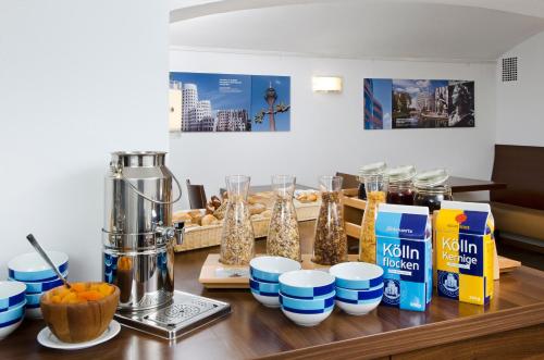 a table with a blender and a bunch of food at Hotel am Hofgarten in Düsseldorf
