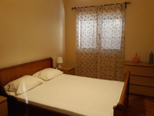 1 dormitorio con 1 cama y una ventana con cortinas en Apartamento Carvoeiro, en Armaes