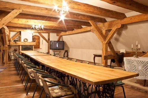 duży drewniany stół w pokoju z krzesłami w obiekcie SHotels przy Restauracji Stodoła w mieście Bartoszyce
