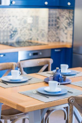 a wooden table with cups and saucers on it at Philoxenia Villas in Panormos Rethymno