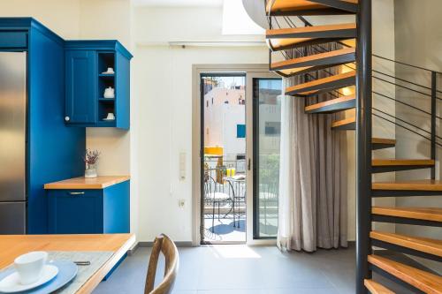 a staircase in a kitchen with blue cabinets and a table at Philoxenia Villas in Panormos Rethymno