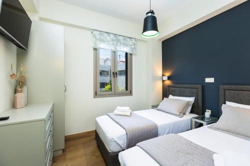 a bedroom with two beds and a window at Philoxenia Villas in Panormos Rethymno