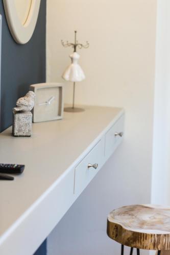 a white counter with a table and a lamp on it at Philoxenia Villas in Panormos Rethymno