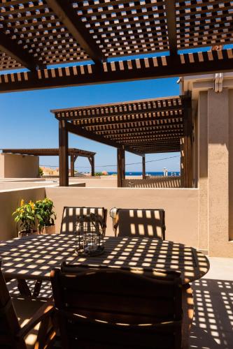 a table and chairs sitting under a pergola on a patio at Philoxenia Villas in Panormos Rethymno
