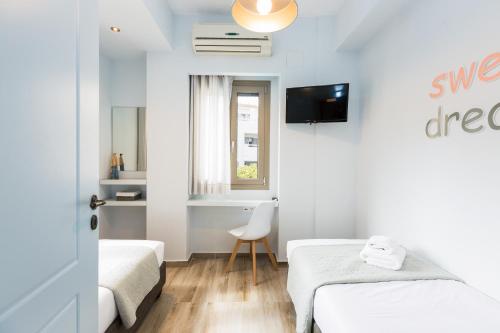 a small room with two beds and a television at Philoxenia Villas in Panormos Rethymno
