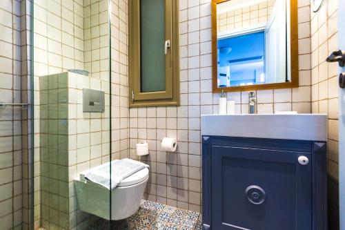 a bathroom with a toilet and a sink and a mirror at Philoxenia Villas in Panormos Rethymno