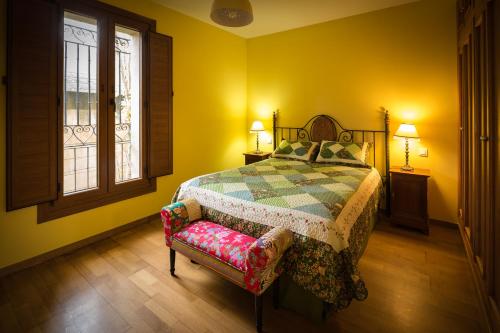 a bedroom with a bed and a chair and two windows at Apartamento turístico Revellin in Logroño