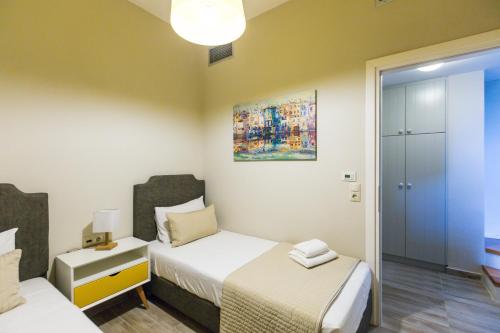 a small bedroom with two beds and a mirror at Philoxenia Villas in Panormos Rethymno