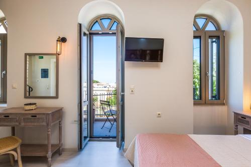 a bedroom with a bed and a desk and a mirror at Philoxenia Villas in Panormos Rethymno