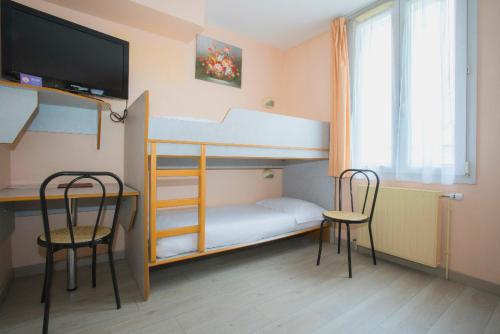 a bedroom with a bunk bed with two chairs and a desk at Hotel De Rosny in Tours